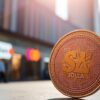 Photograph of a Solana coin with urban background.